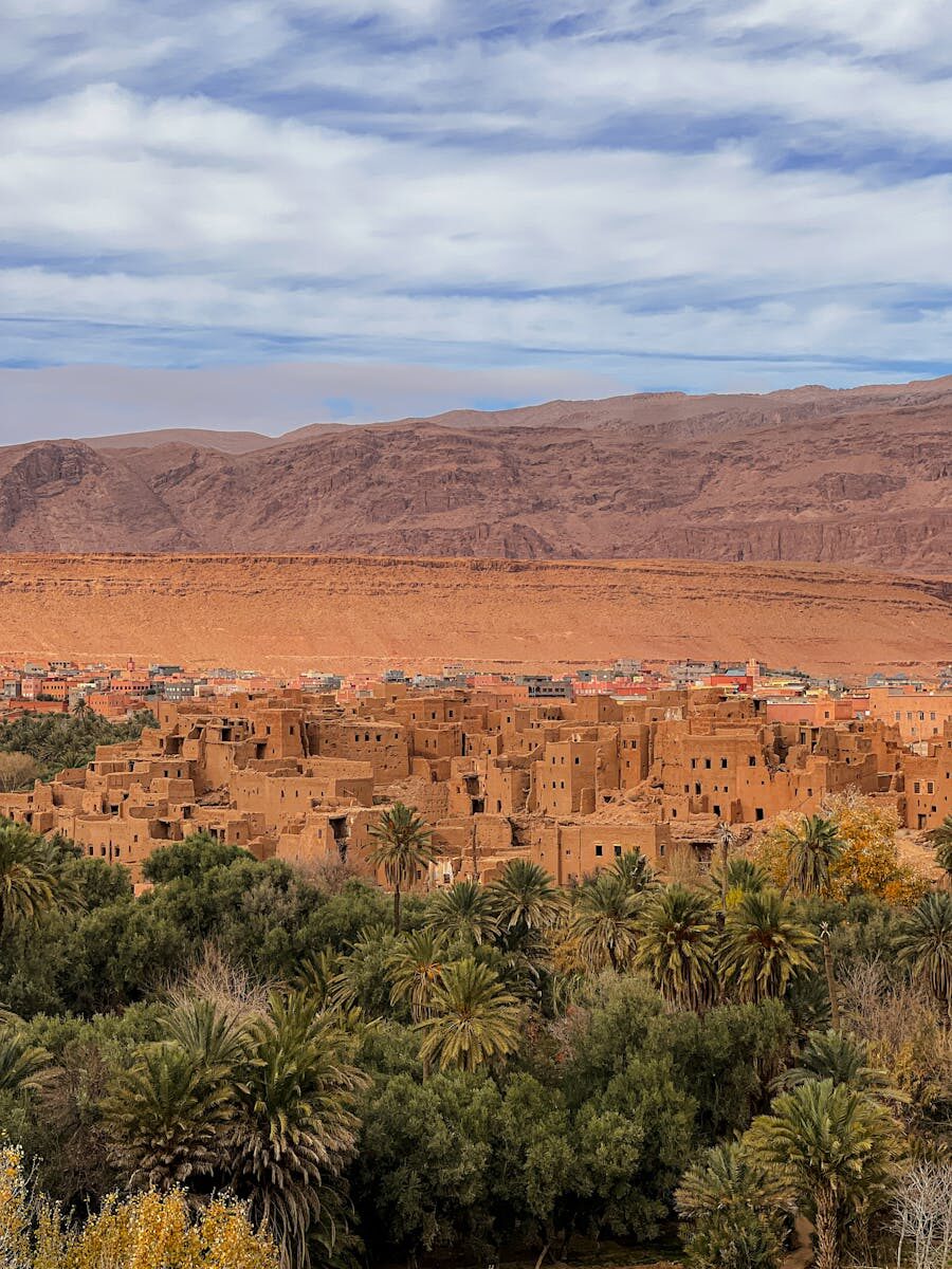 Explore the rustic beauty of an ancient desert village in Morocco with a backdrop of the Atlas Mountains.