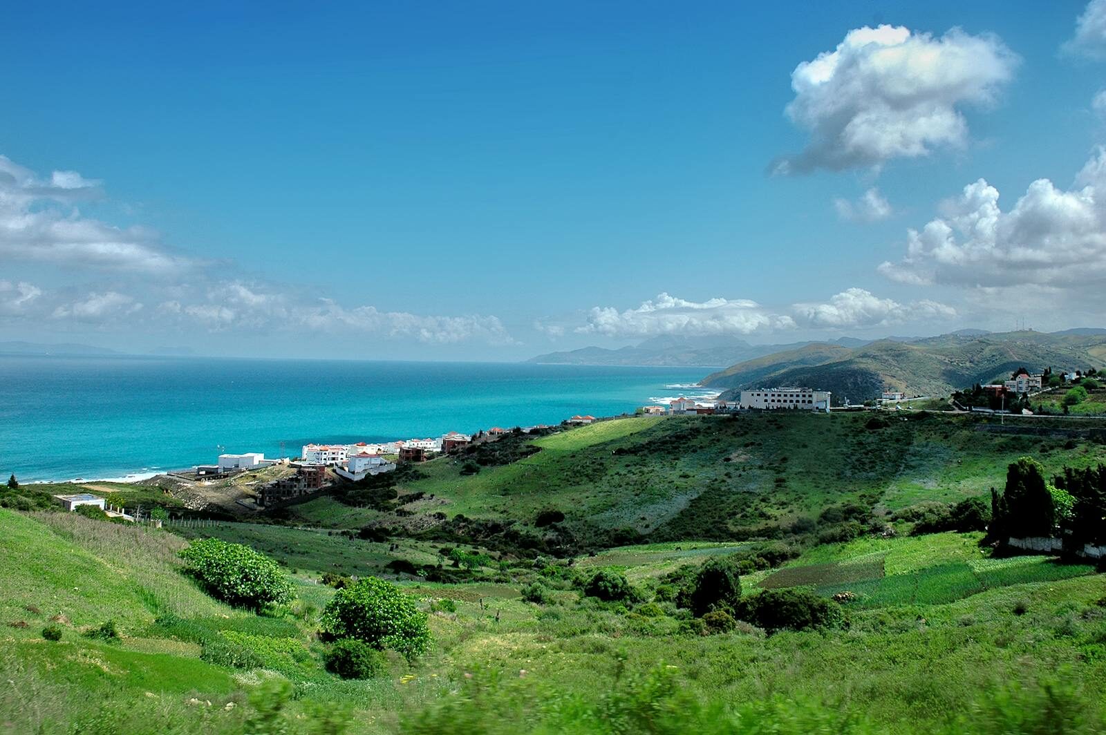 Breathtaking view of Tétouan's coastline with vibrant greenery and blue sea under a clear sky.